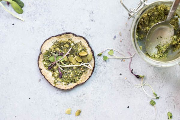Eggplant Toast topped with Pesto, pepitas and sprouts. Savory Mediterranean flavors!